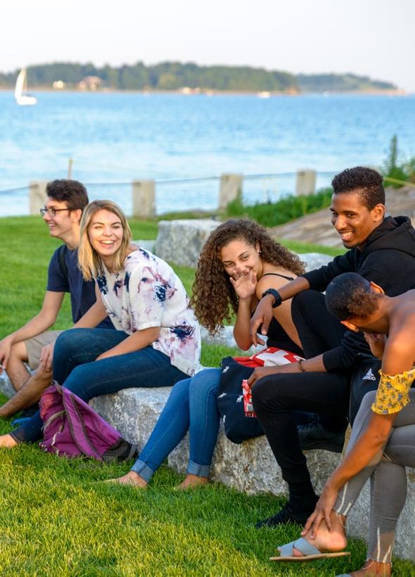 Students Sitting on Stone Blocks on Campus Center Lawn